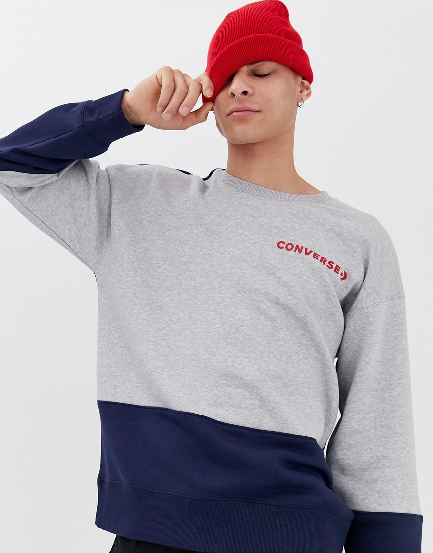 A picture of a man wearing a colour-blocked Converse sweatshirt and red beanie. Available at ASOS.