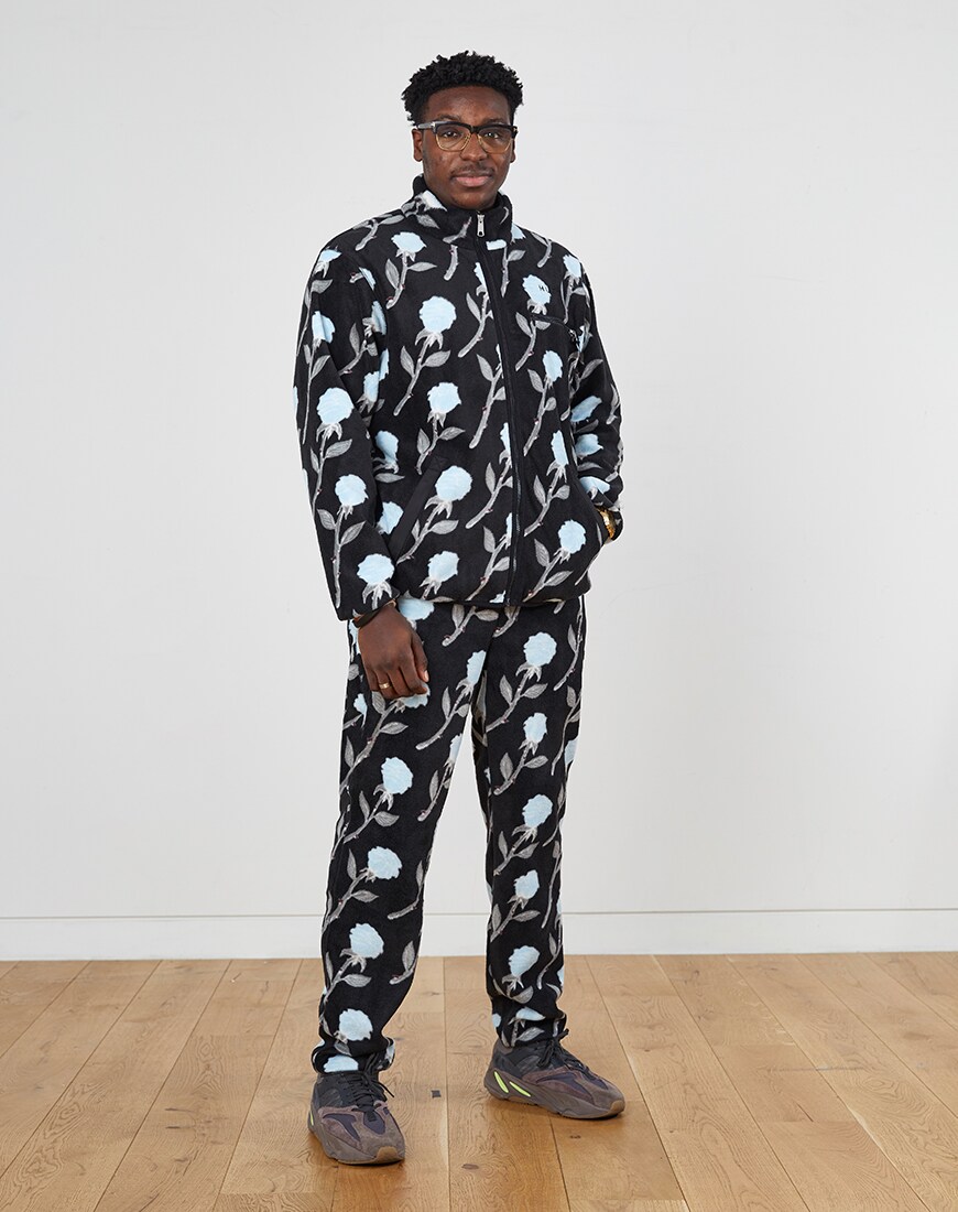 A picture of a man wearing a floral print, fleece tracksuit. Available at ASOS.