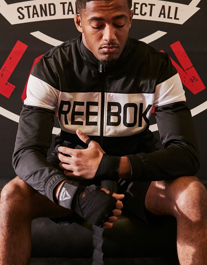 A picture of a man in the gym wearing a Reebok track top and shorts. Available at ASOS.