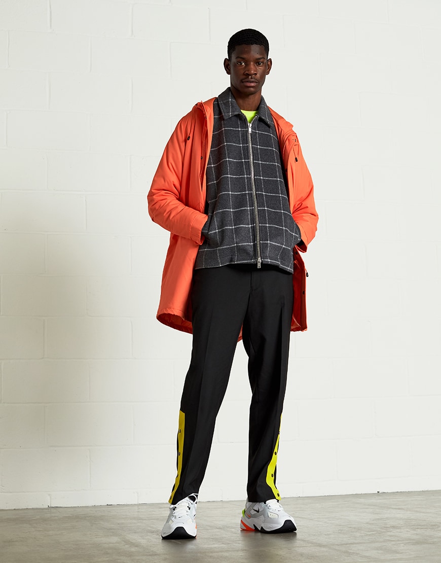A picture of a neon-inspired outfit featuring a coat, jacket, T-shirt, sporty joggers and chunky