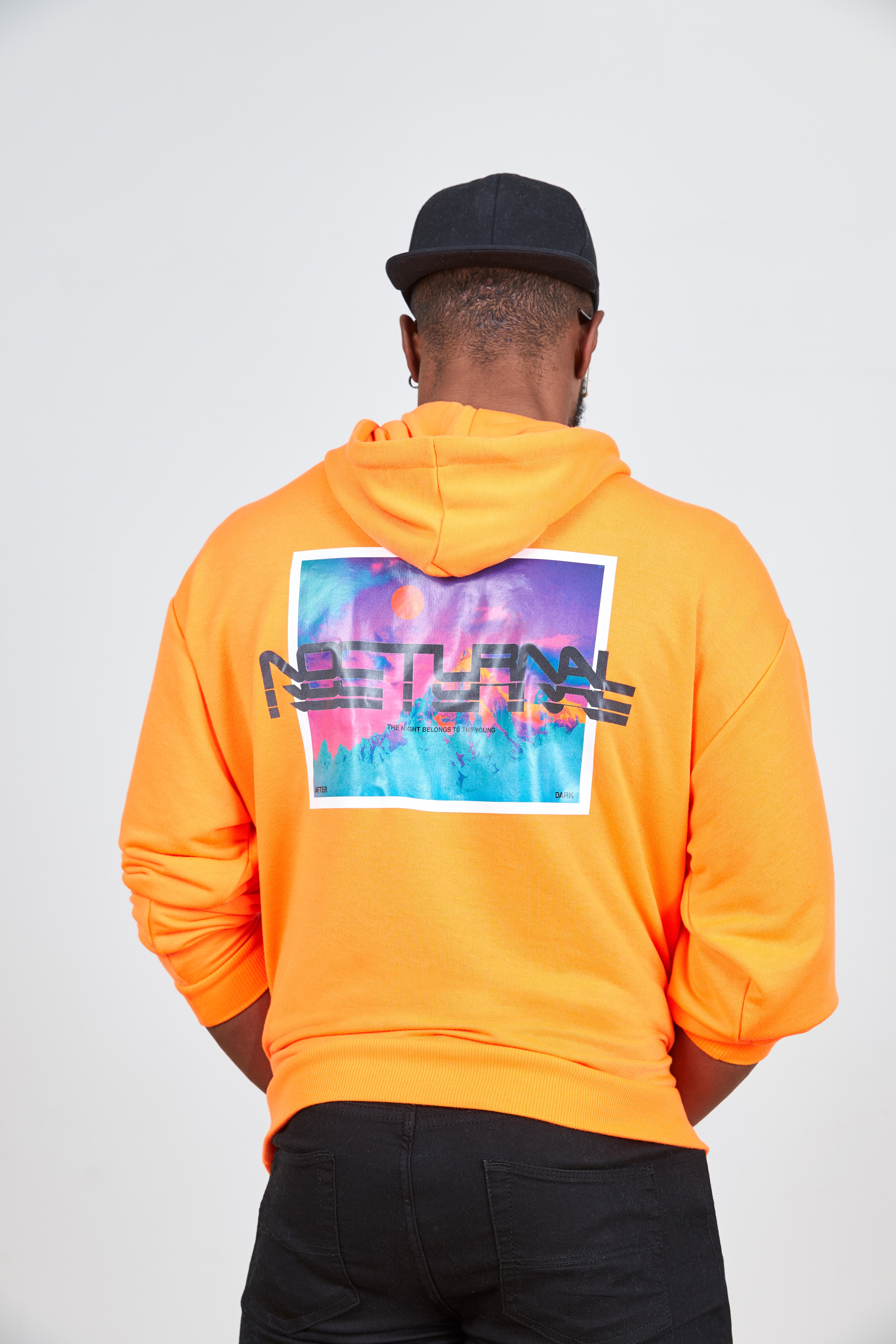 A close up picture of a neon orange hoodie with a colourful back print. Available at ASOS.