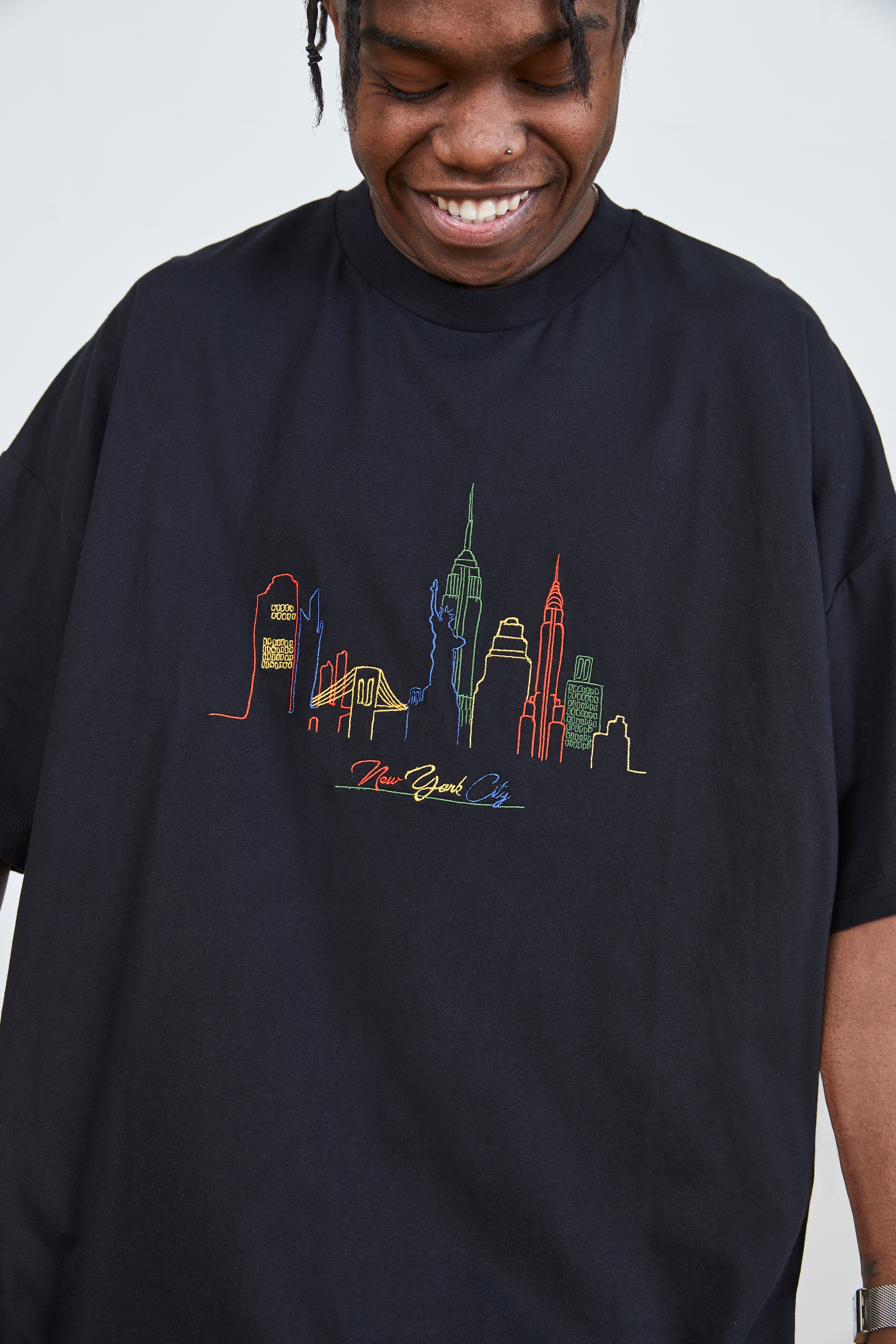 A close up picture of a black T-shirt with and embroidered cityscape design. Available at ASOS.