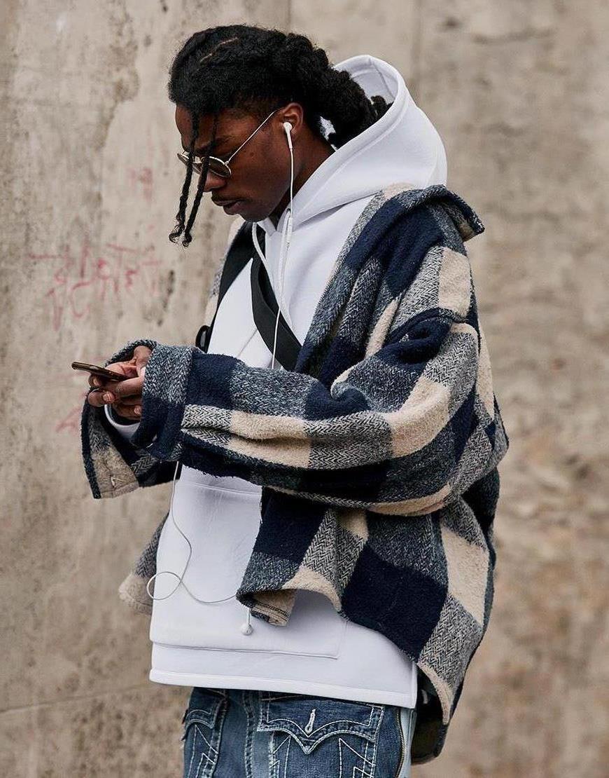 A street-styler wearing a white hoodie, oversized checked jacket and baggy blue jeans | ASOS Style Feed