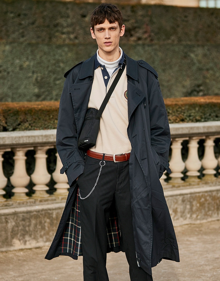 A street-styler in Paris wearing a navy trench coat, cream rugby shirt and dark pinstripe trousers  | ASOS Style Feed