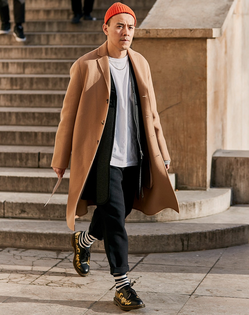 A picture of a streetstyler wearing a camel coat and longline cardigan combination.
