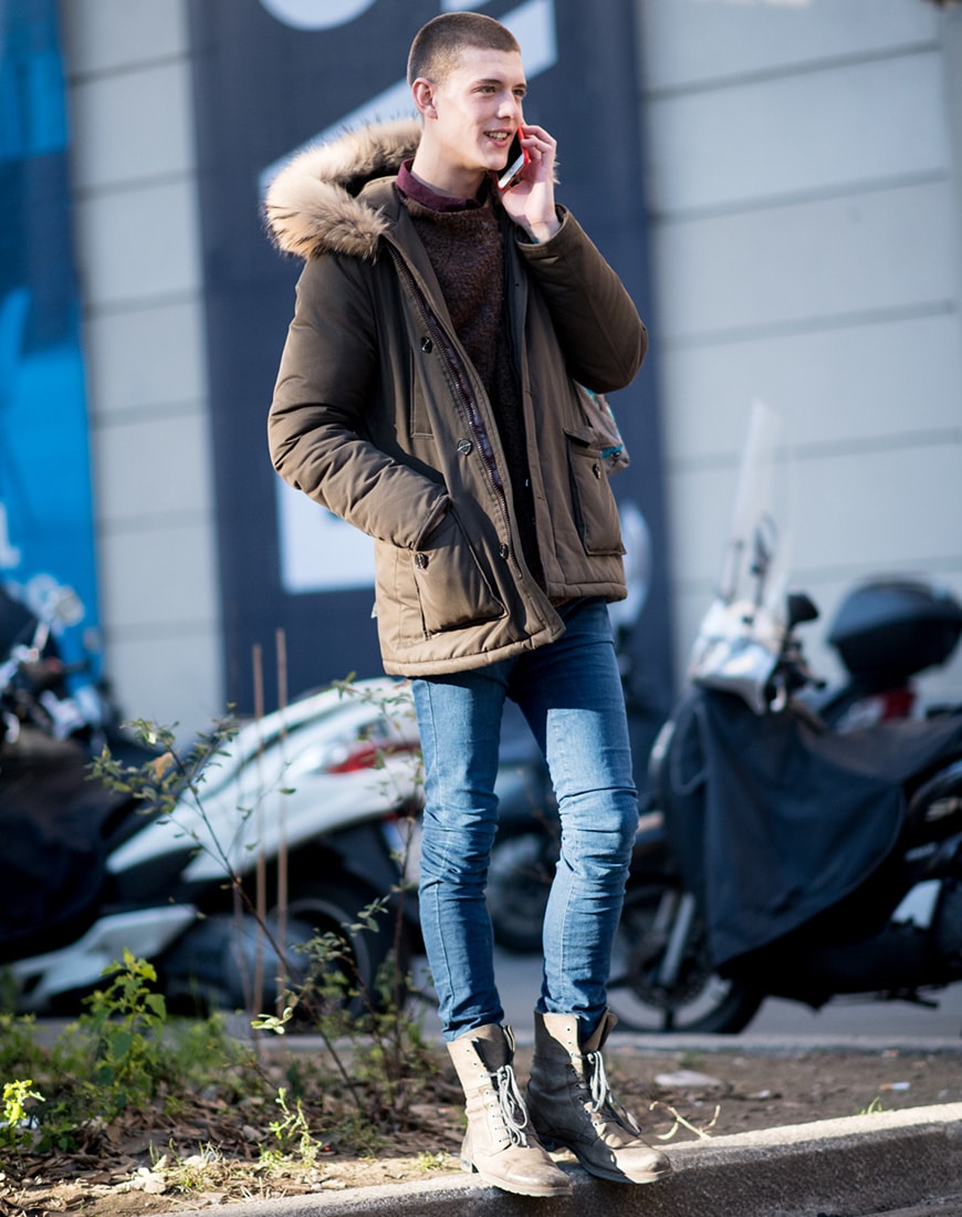 A picture of a streetstyler wearing a parka with a knitted jumper and skinny jeans.