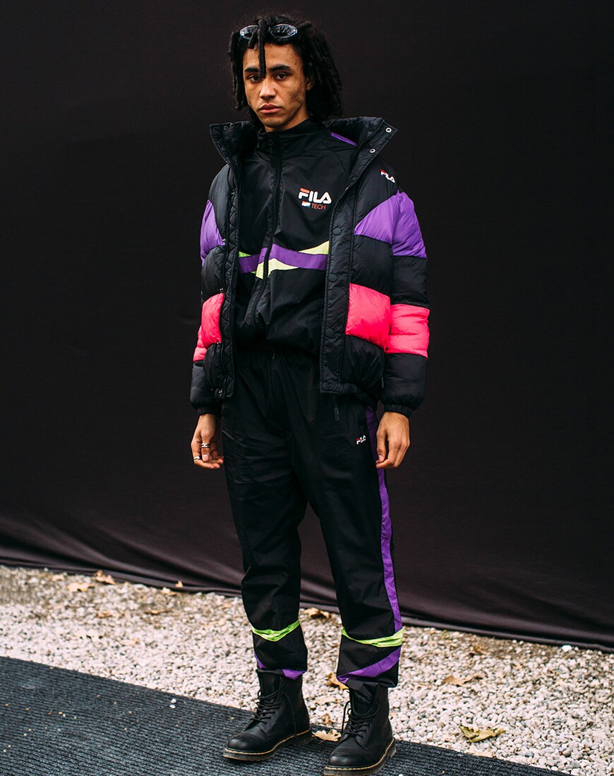 A picture of a streetstyler wearing a Fila puffer jacket, track top and joggers with Dr Martens boots.