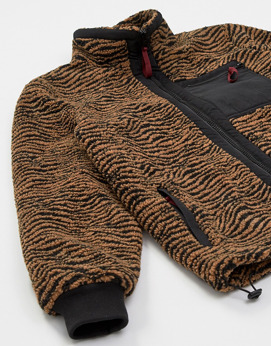 A close up picture of a zebra-stripe fleece jacket. Available on ASOS.