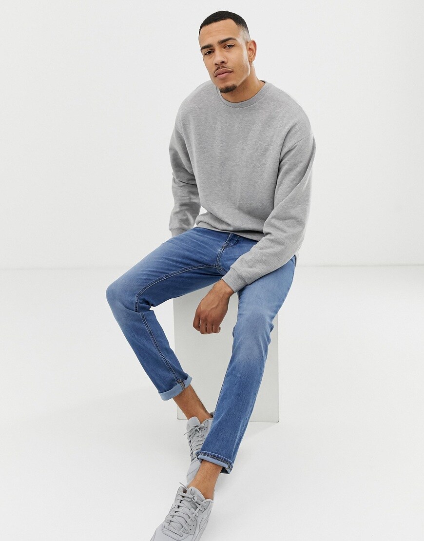 A picture of a man wearing an oversized sweatshirt by ASOS DESIGN Tall