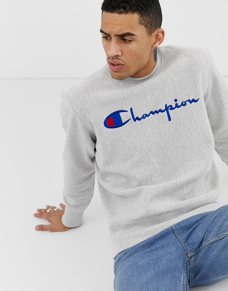 A picture of a man wearing a grey Champion sweatshirt. Available at ASOS.