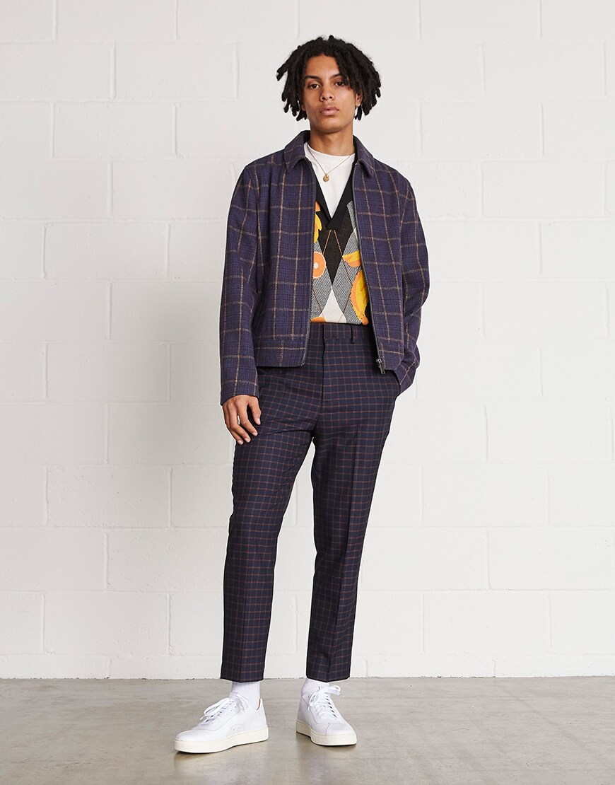 A picture of a man wearing a navy, check suit and a vibrant, short-sleeve jumper. Available at ASOS.
