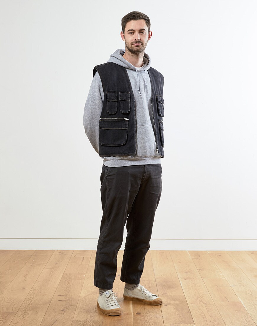 A picture of a man wearing a washed black, denim gilet. Available at ASOS.