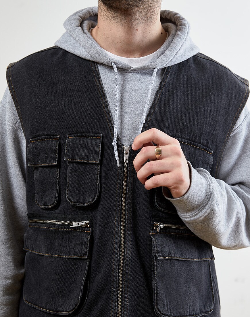 A close up picture of a washed black, denim gilet. Available at ASOS.