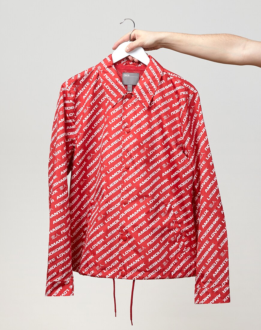 A picture of a red and white coach jacket with an all-over text print. Available on ASOS.