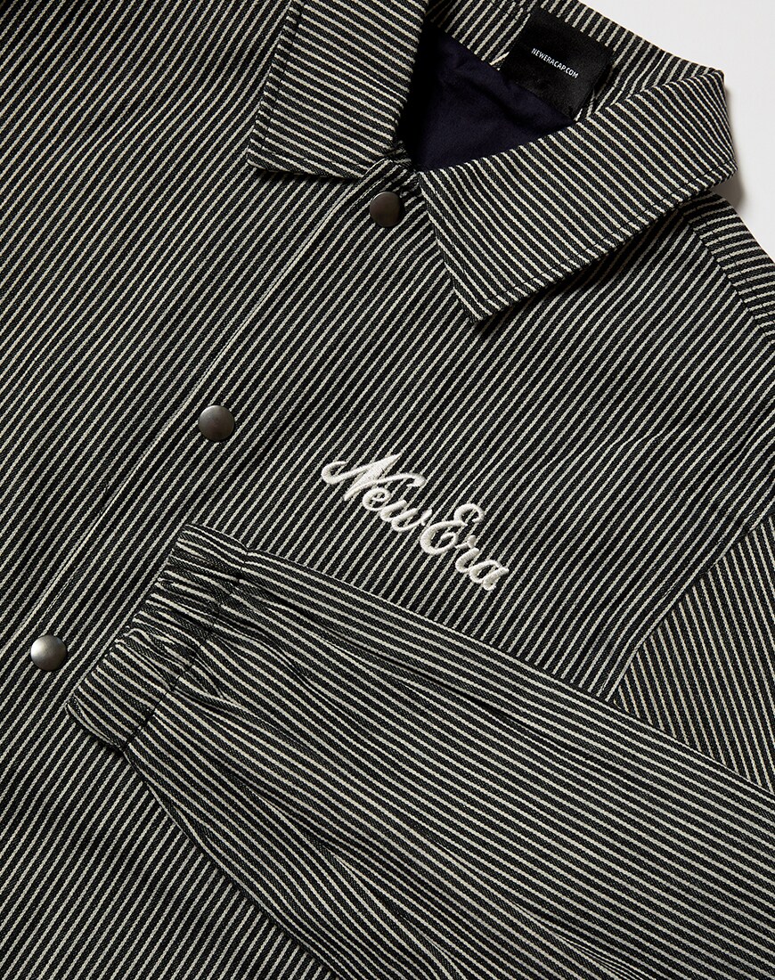 A close up picture of a pinstripe New Era coach jacket. Available on ASOS.
