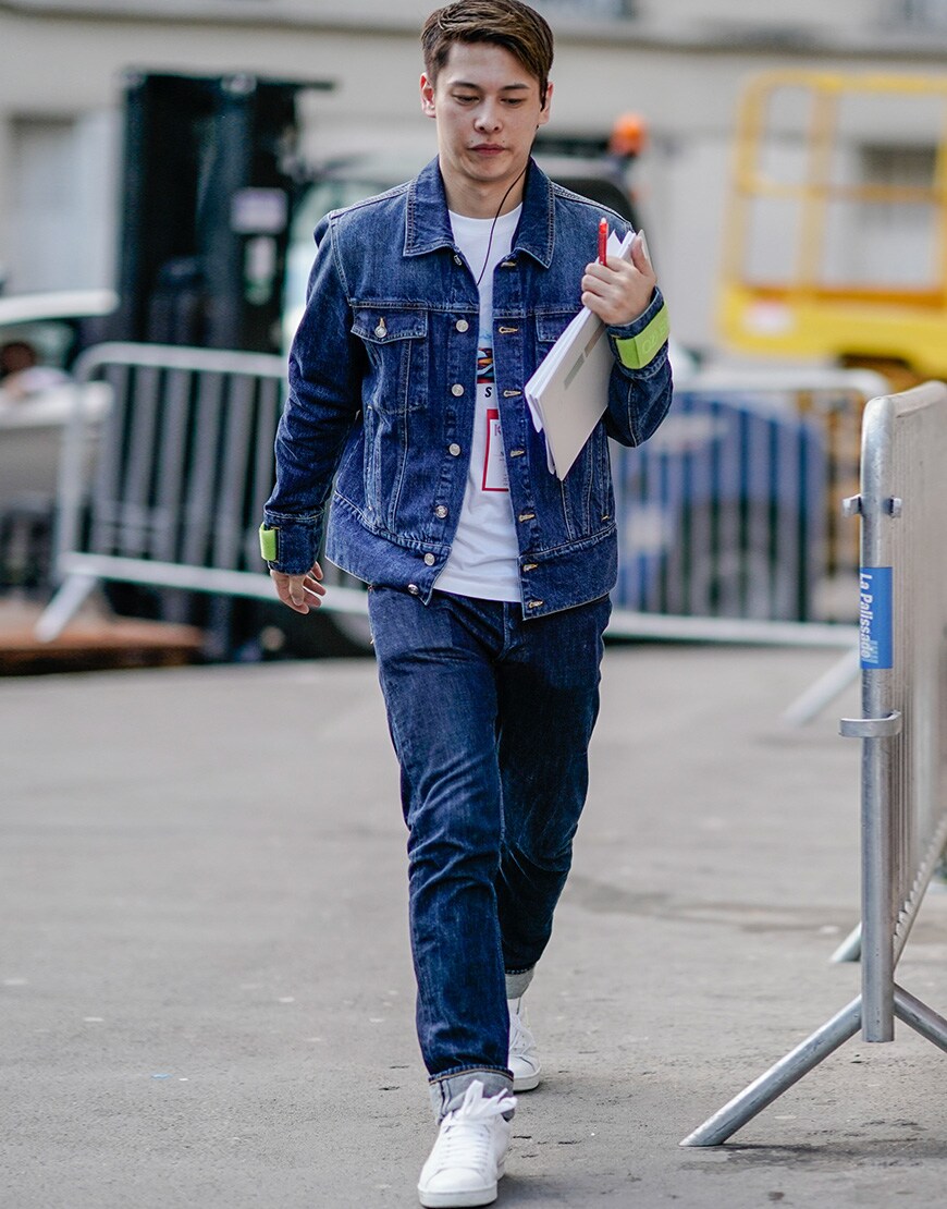 A picture of a street styler wearing a denim jacket and jeans.