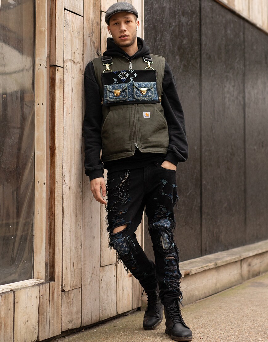 A picture of a street styler wearing a gilet and ripped jeans