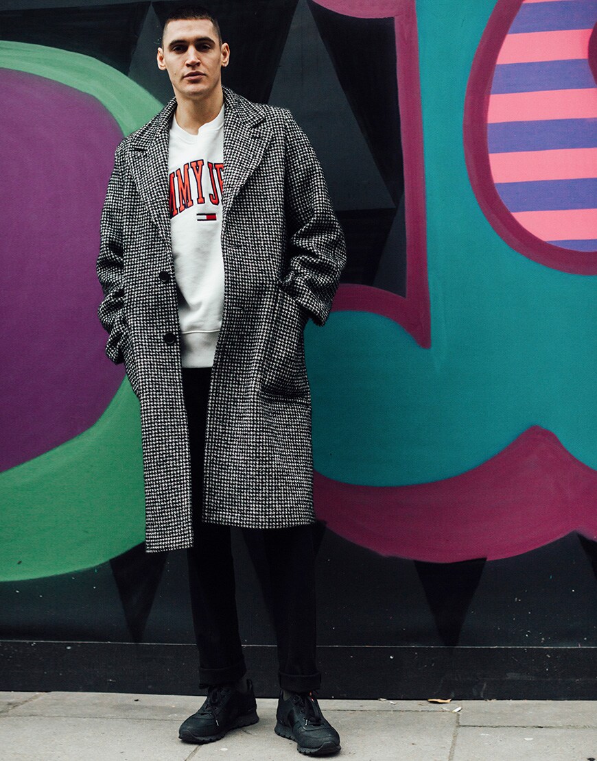 A picture of a street styler wearing an overcoat.
