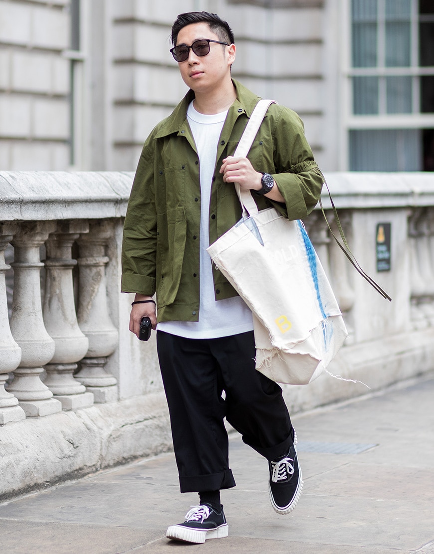 A picture of a street styler wearing an overshirt and wide-cut trousers.