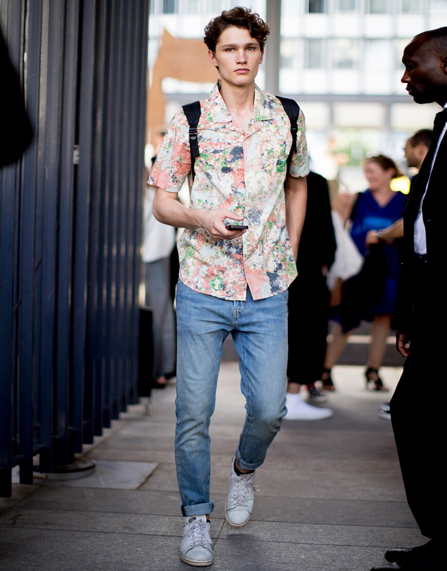 A picture of a street styler wearing a pair of light wash jeans and a floral-print shirt.