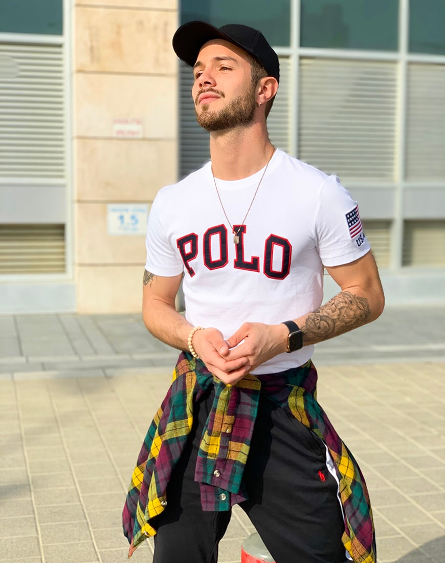 A picture of an ASOS Insider wearing a Polo Ralph Lauren varsity T-shirt, check shirt and joggers. Available at ASOS.