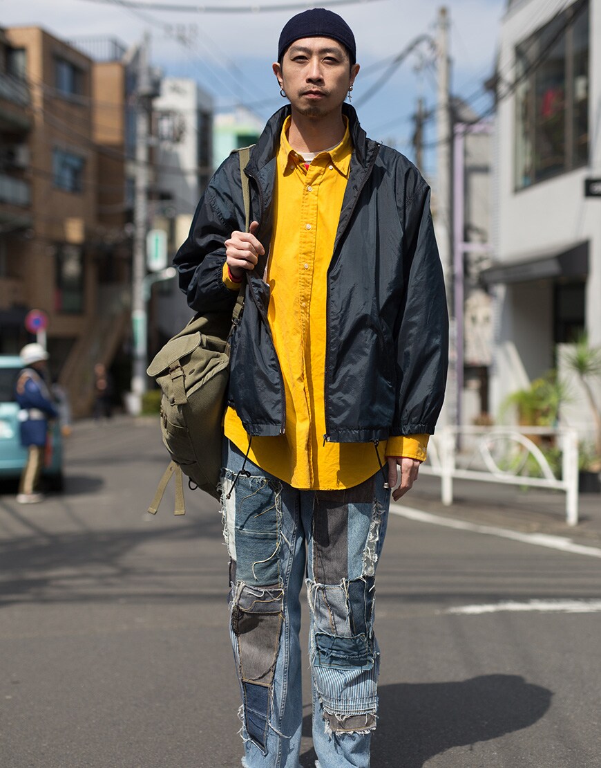 A picture of a street styler wearing a yellow shirt.