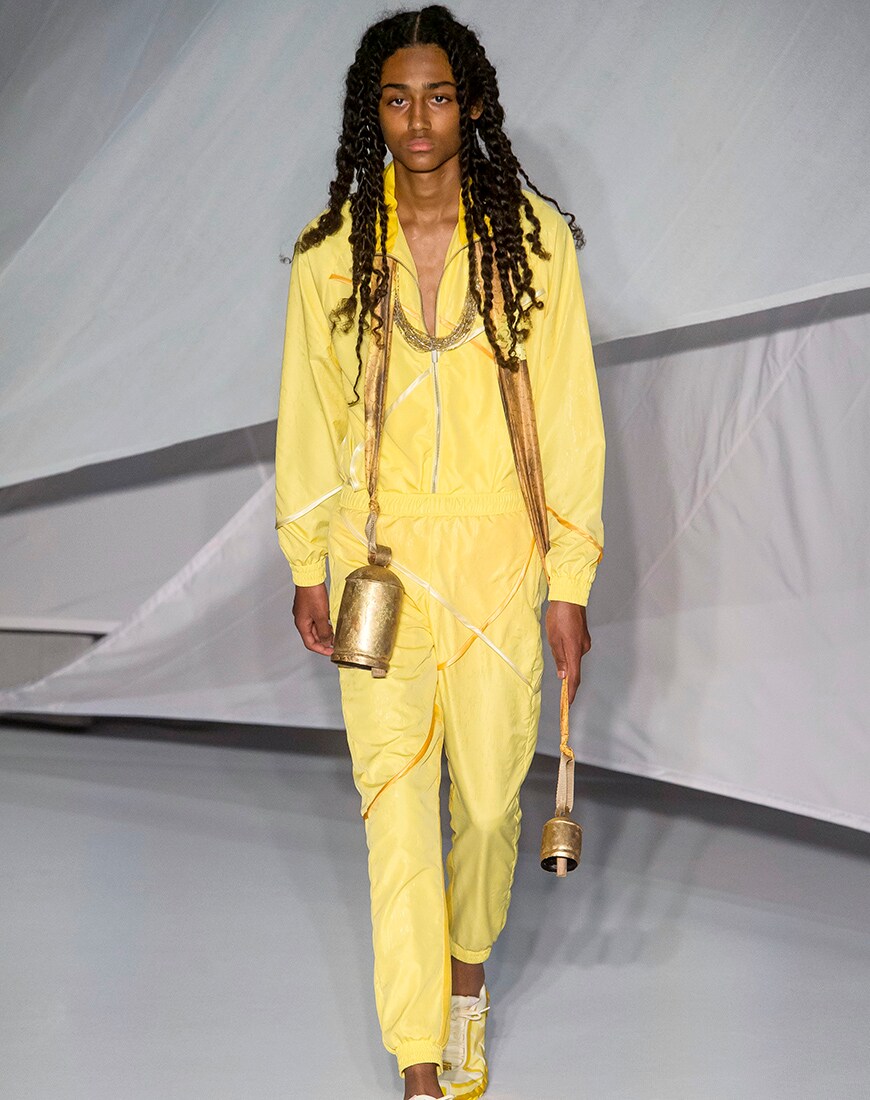 A picture of a runway model wearing a yellow outfit.