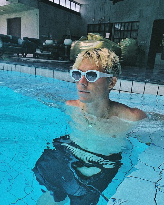 ASOS Jono ist in einem Pool und trägt eine Retro-Sonnenbrille