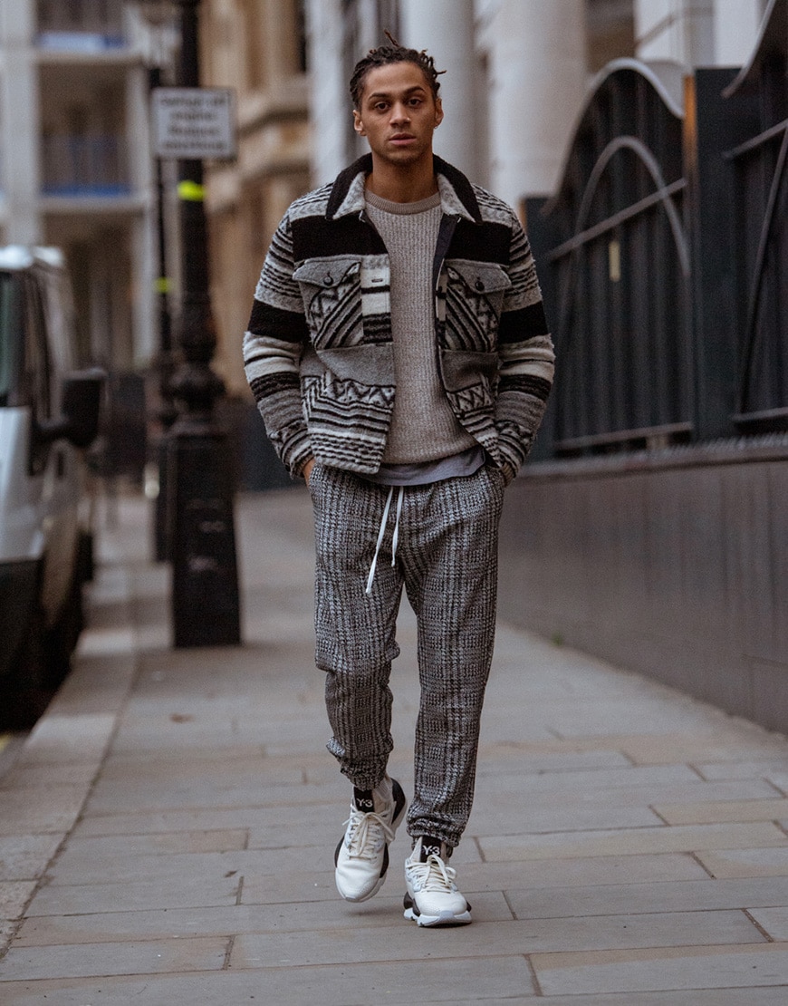 A picture of a street styler in an overshirt and and printed trousers.
