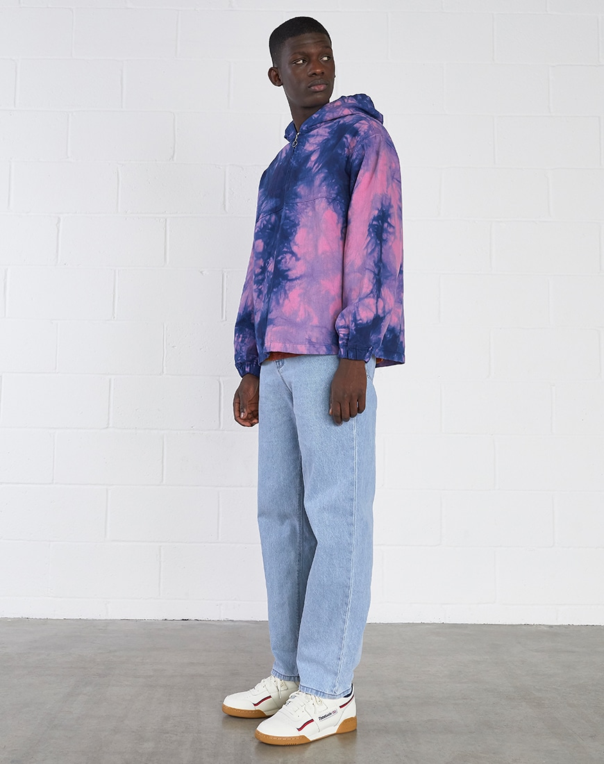 A picture of a model wearing a tie-dye hoodie, light-wash jeans and adidas Continental trainers. Available at ASOS.