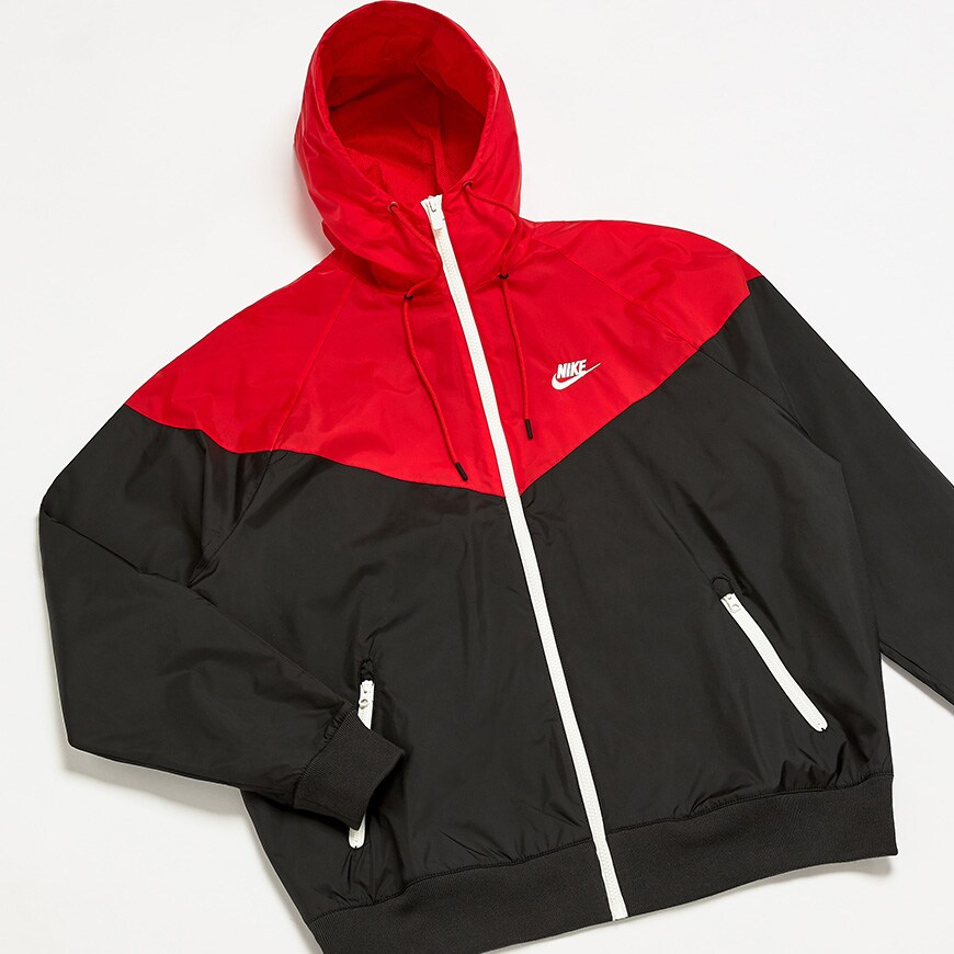 A picture of a red and navy colour-blocked rain jacket by Nike. Available at ASOS.