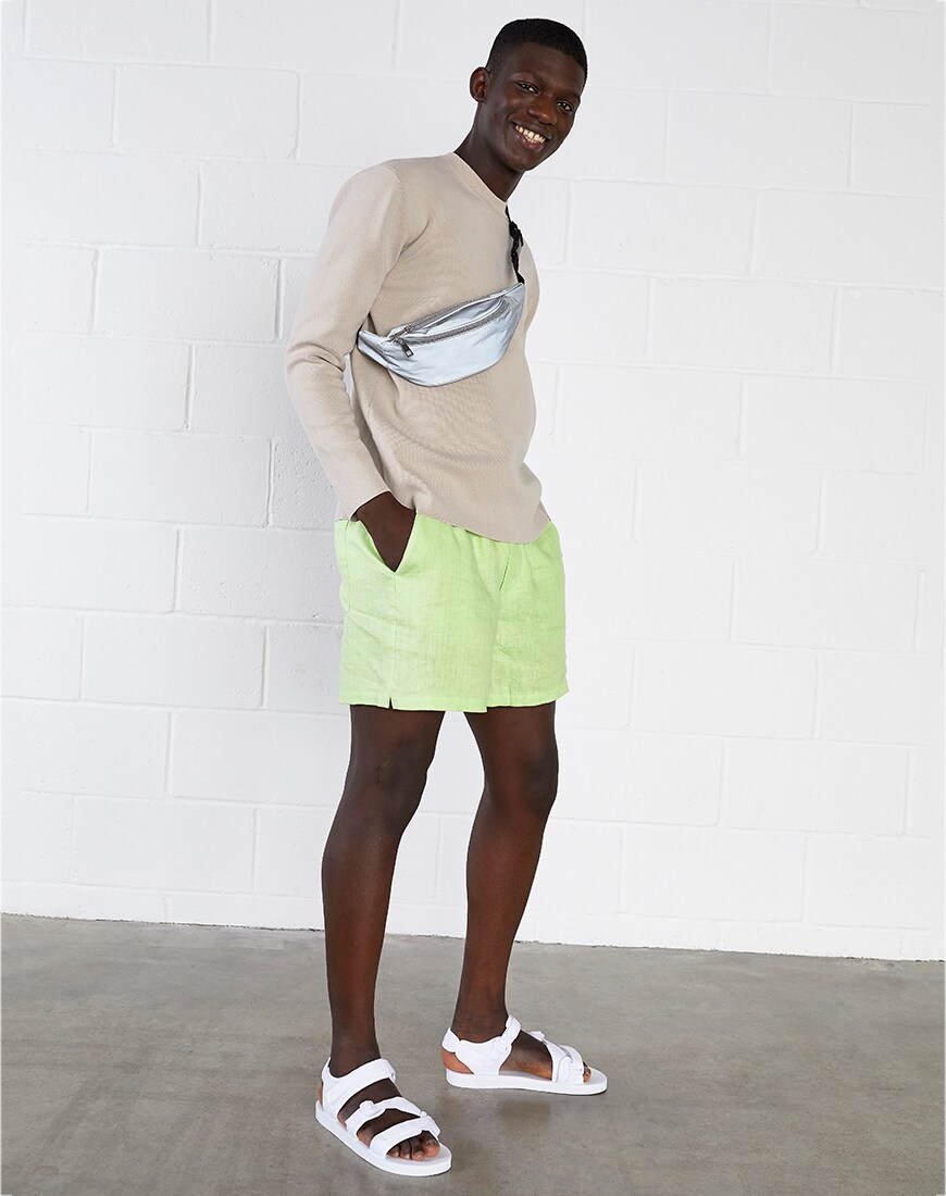 A picture of a model wearing a lightweight knit and washed-neon shorts. Available at ASOS.