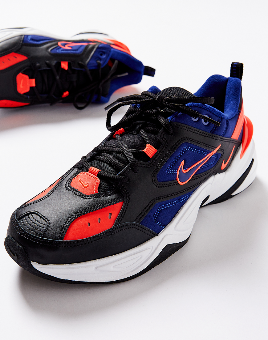 A picture of a pair of Nike MK2 Tekno trainers in a black, blue and orange colourway. Available at ASOS.