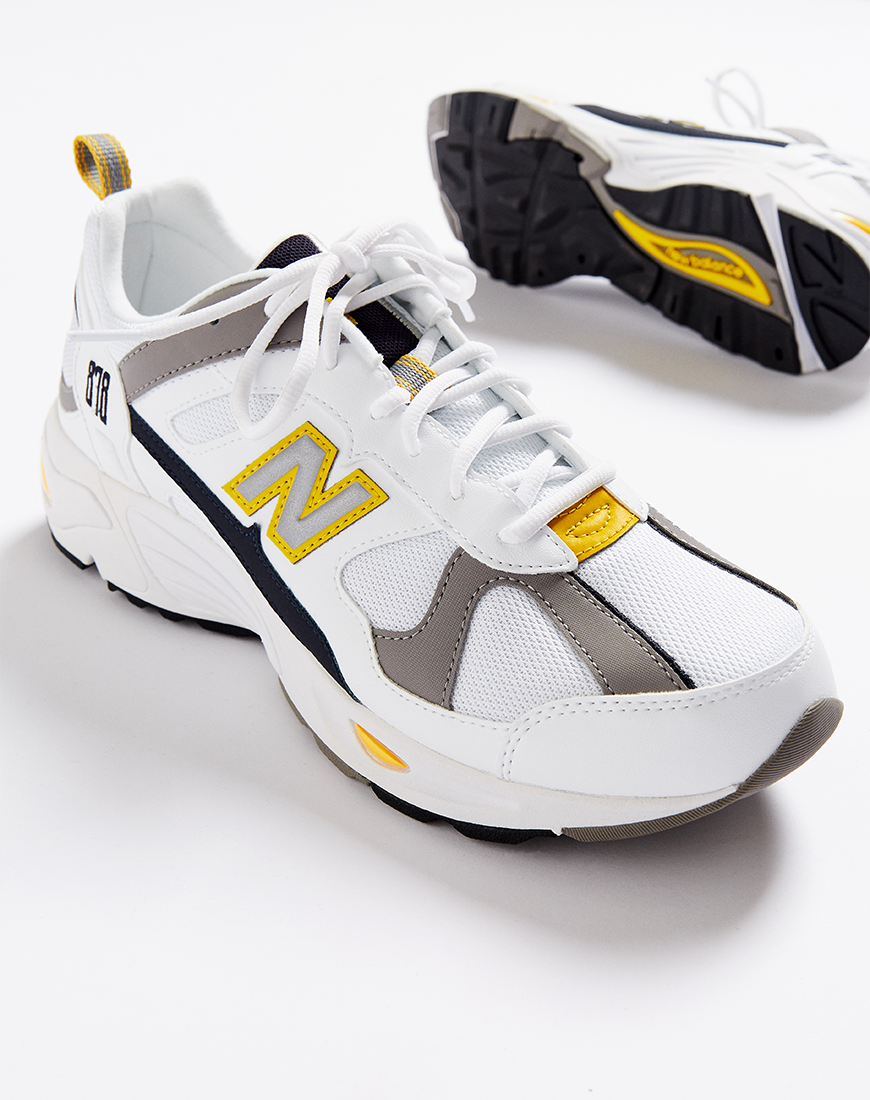 A picture of a pair of New Balance 878 trainers in a white, grey and yellow colourway. Available at ASOS.