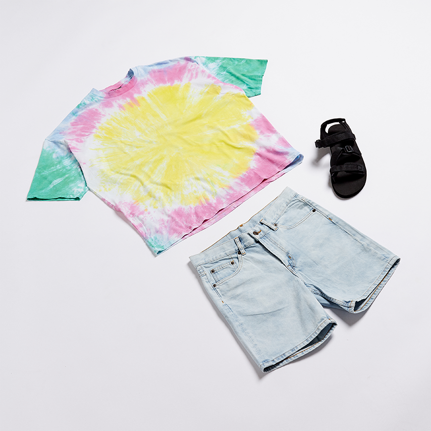 A picture of  flat lay outfit including a tie-dye T-shirt, light-wash denim shorts and techy sandals. Available at ASOS.