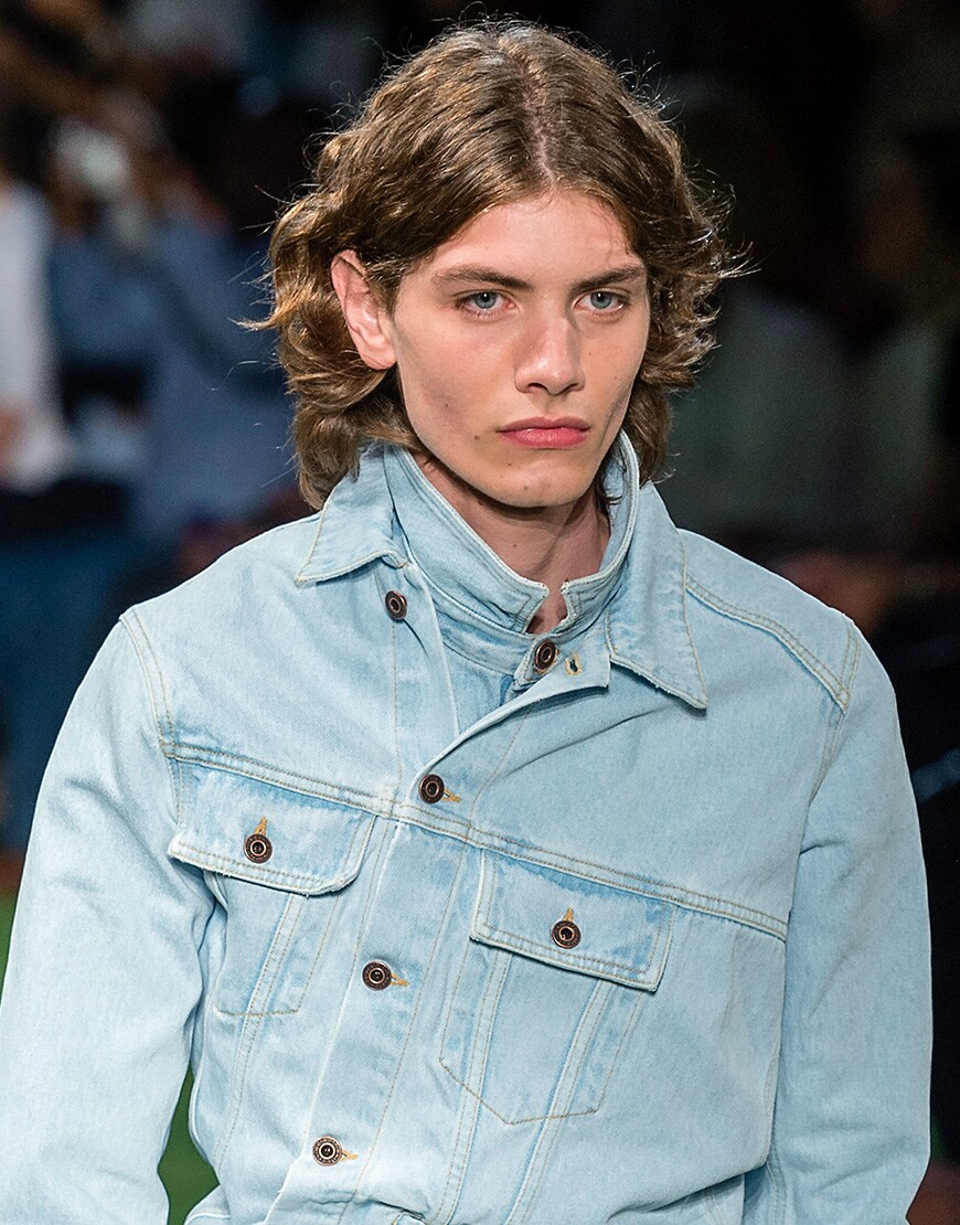 A picture of a model with mid-length hair, parted at the front.