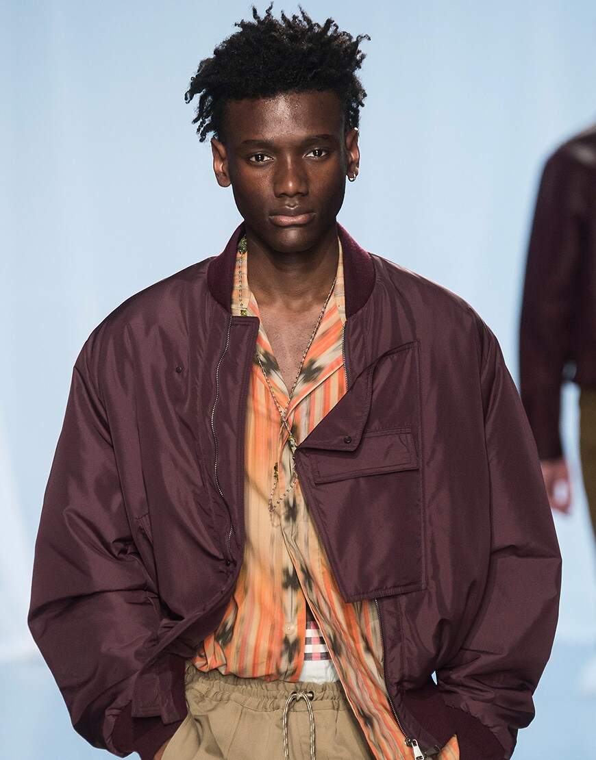 A picture of a model with a relaxed afro hairstyle at the SS19 men's Fashion Week.