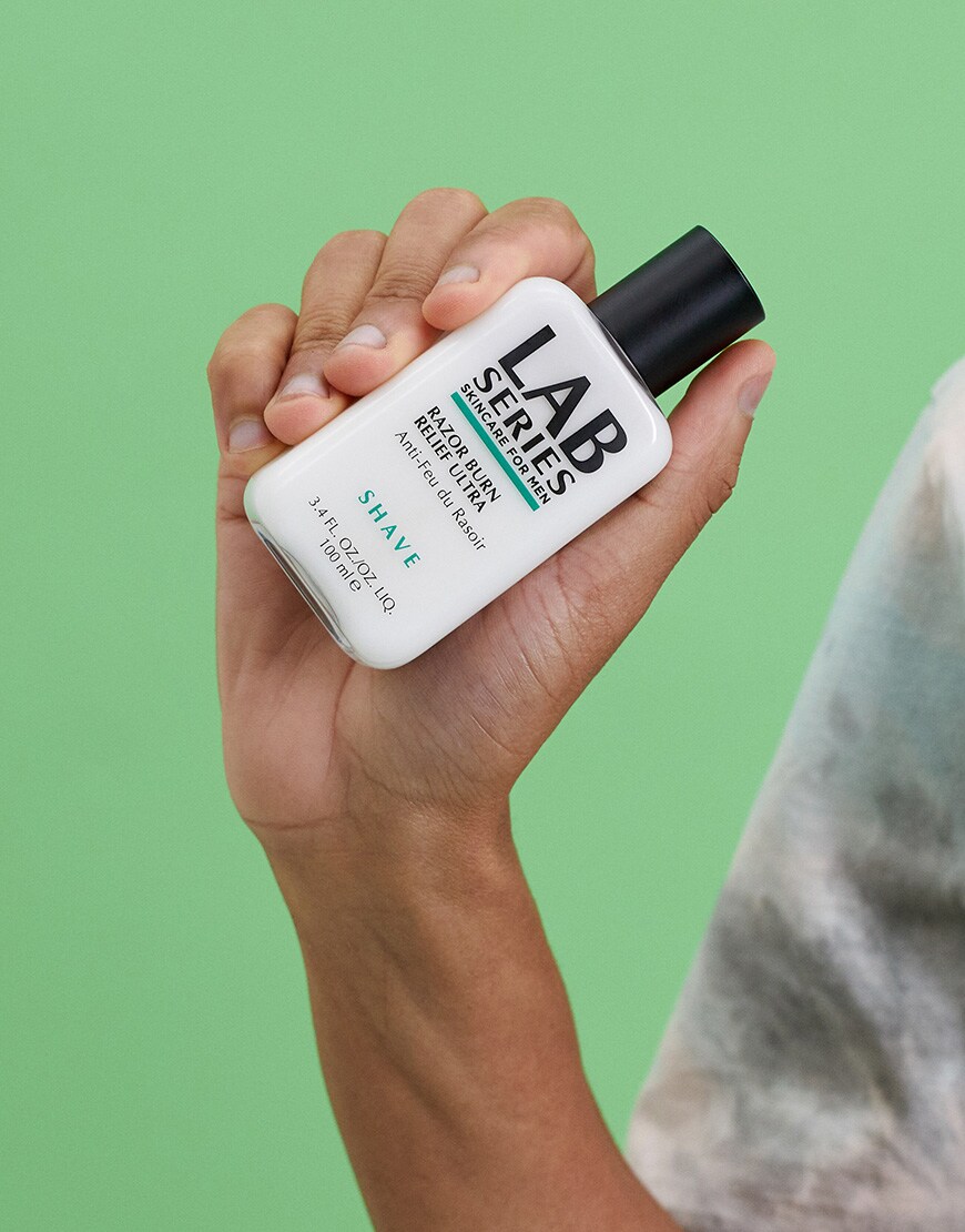 A picture of a model holding Lab Series Razor Burn Relief cream. Available at ASOS.