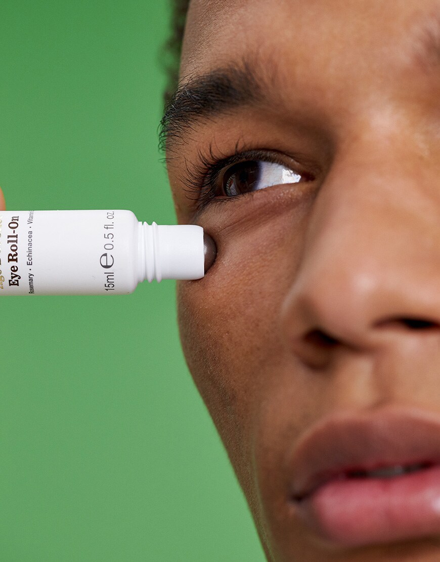 A picture of a model using an eye roll-on serum from Bulldog. Available at ASOS.