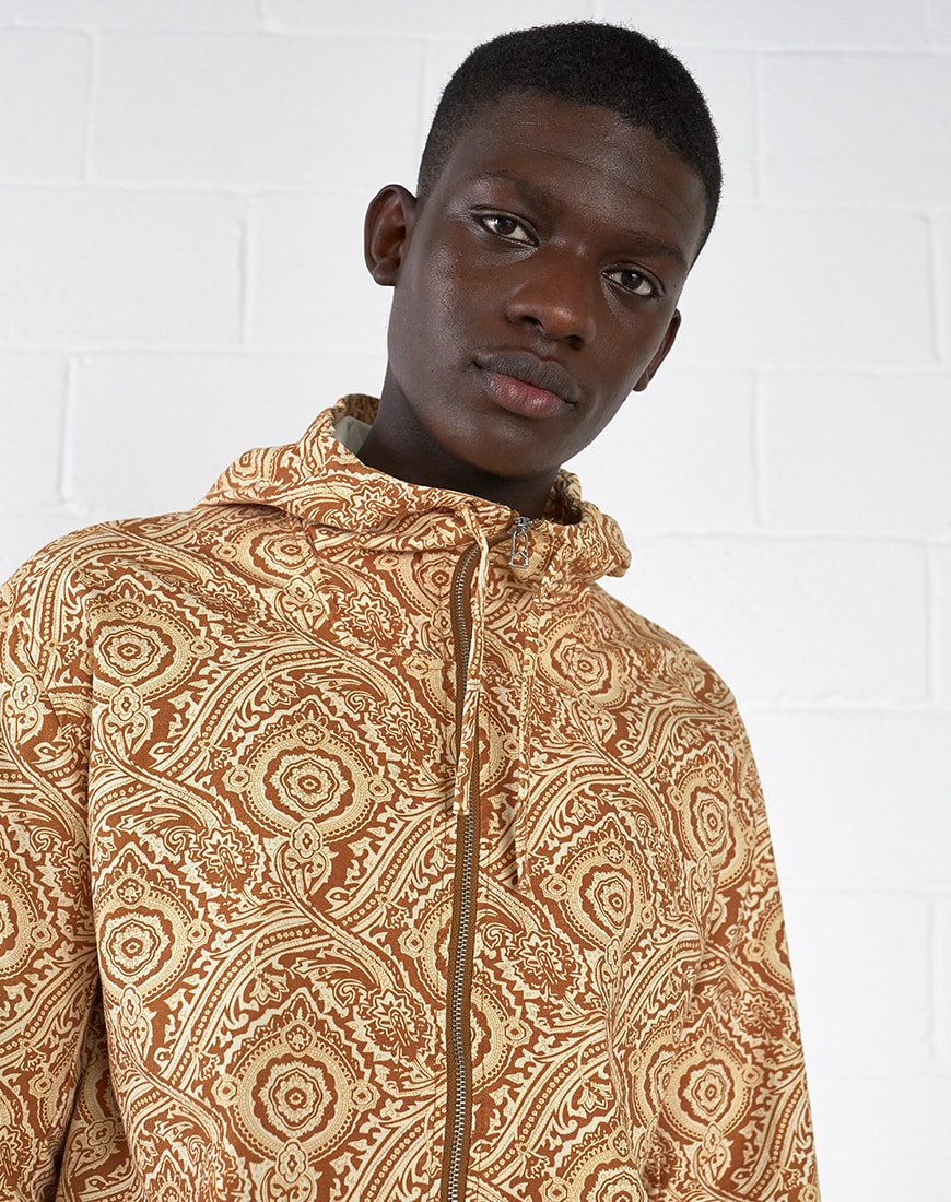 A close-up picture of a model wearing a paisley print jacket. Available at ASOS.
