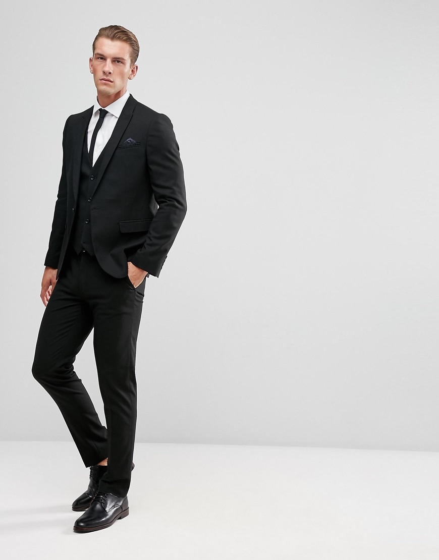 A picture of a model wearing a black three-piece suit and black shoes. Available at ASOS.