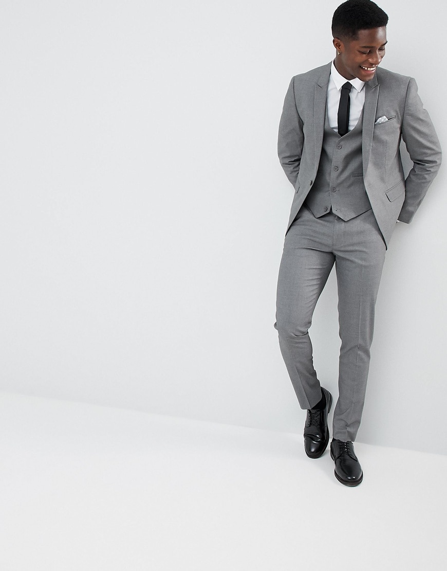 A picture of a model wearing a grey three-piece suit and black shoes. Available at ASOS.