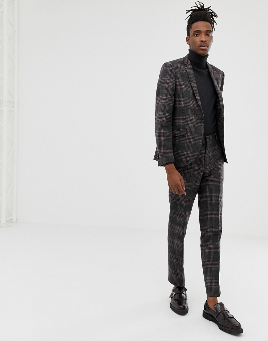 A picture of a model wearing a charcoal, check suit with a roll-neck jumper and burgundy loafers. Available at ASOS.