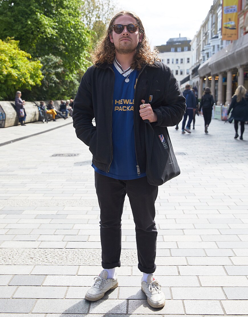 A picture of a man wearing a Carhartt WIP denim chore jacket and Reebok Club C trainers. 