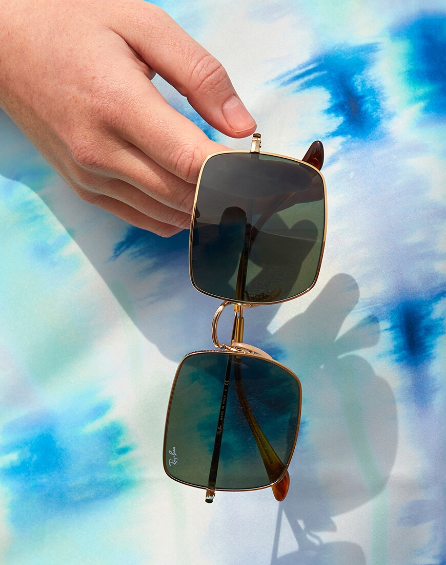 A picture of an ASOS Insider holding Ray-Ban sunglasses. Available at ASOS.