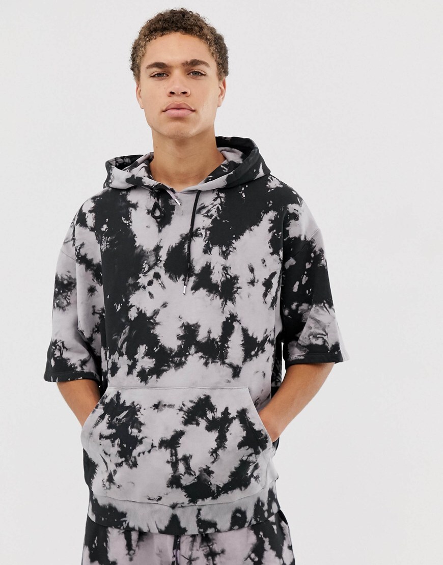 A picture of a model wearing an oversized hoodie and jersey shorts co-ord. Available at ASOS.