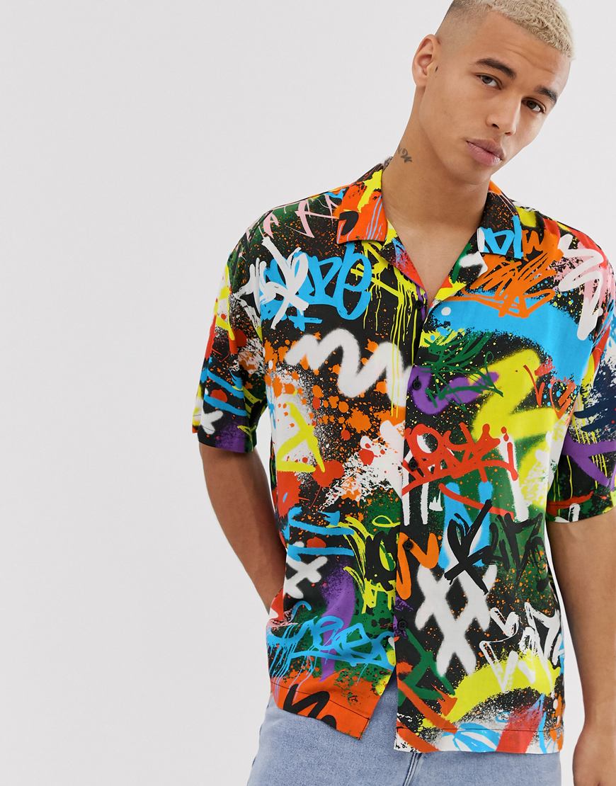 A picture of a model wearing a graffiti print shirt by Jaded London. Available at ASOS.
