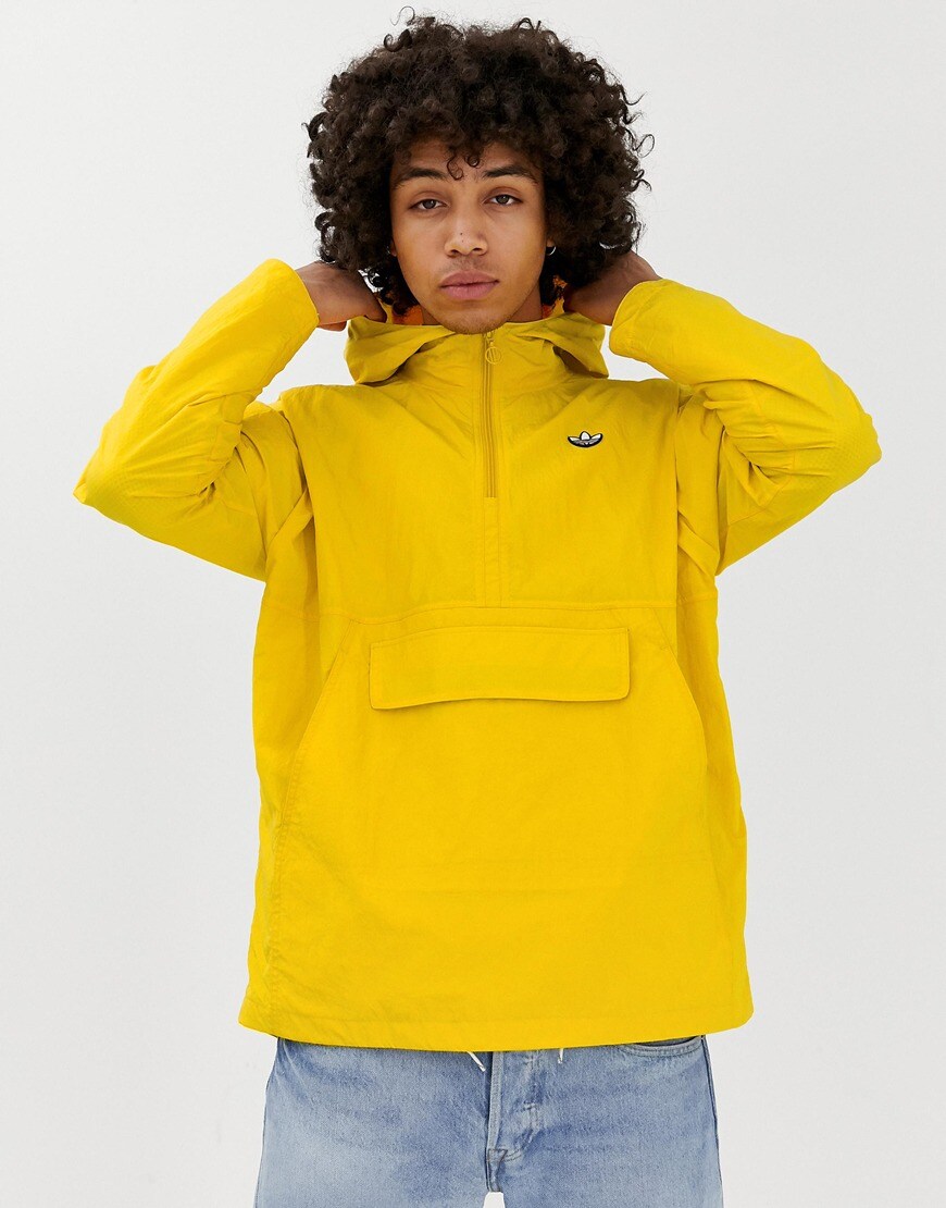 A picture of a model wearing a bright yellow wind breaker jacket by adidas Originals. Available at ASOS.