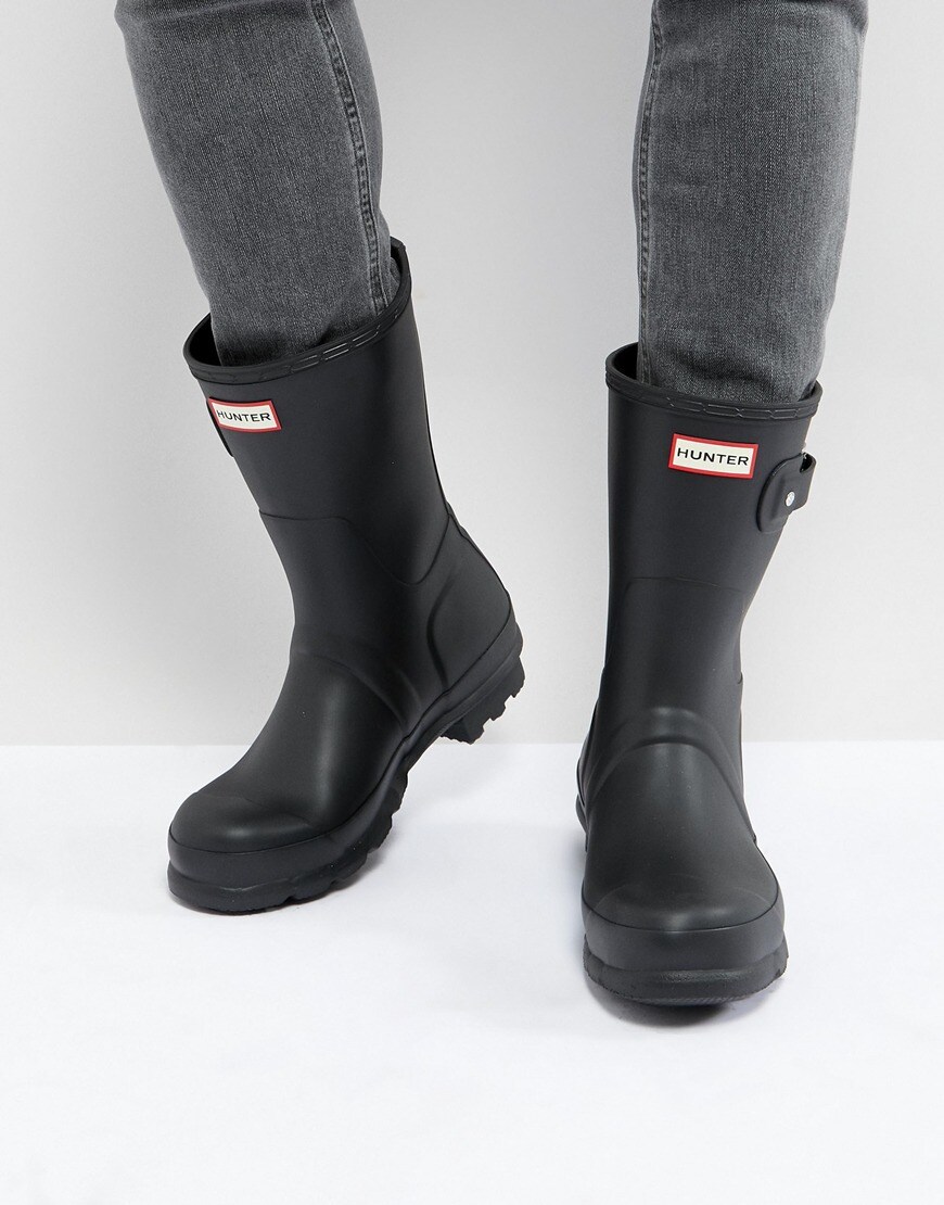 A picture of a model wearing a pair of black Hunter wellies. Available at ASOS.