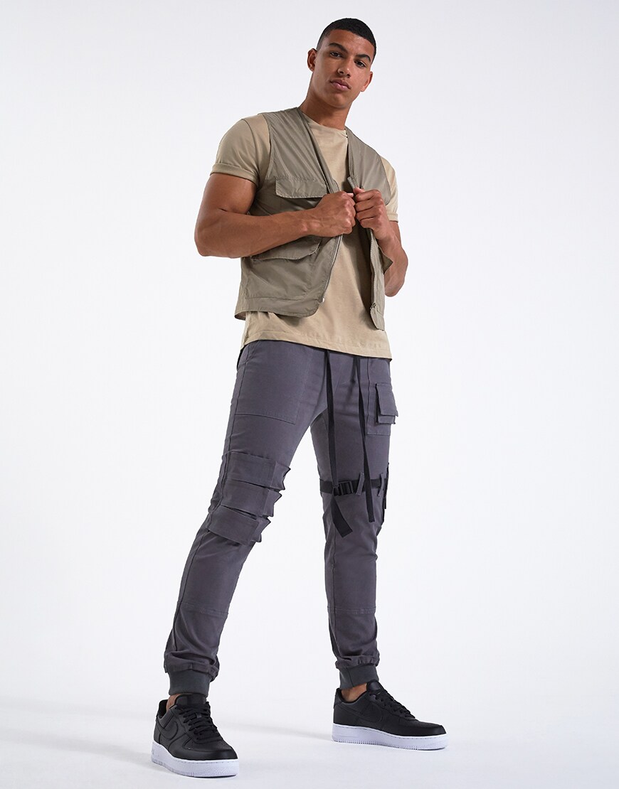 A picture of a model wearing a khaki T-shirt, a utility-style gilet and cargo trousers. Available at ASOS.
